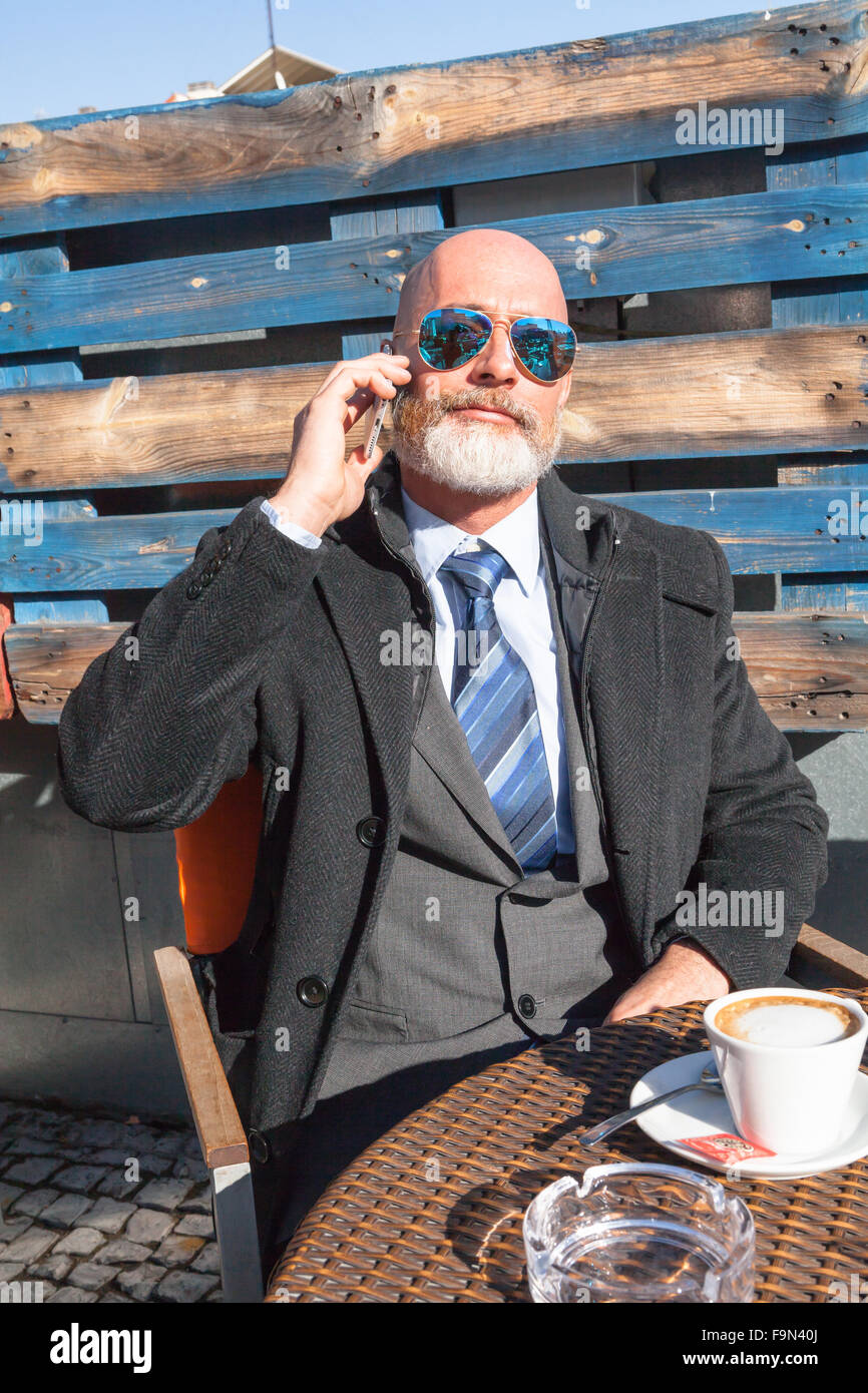 Homme d'âge moyen , beau et élégant à l'extérieur du bureau de travail dans une ambiance détendue et ensoleillée Banque D'Images