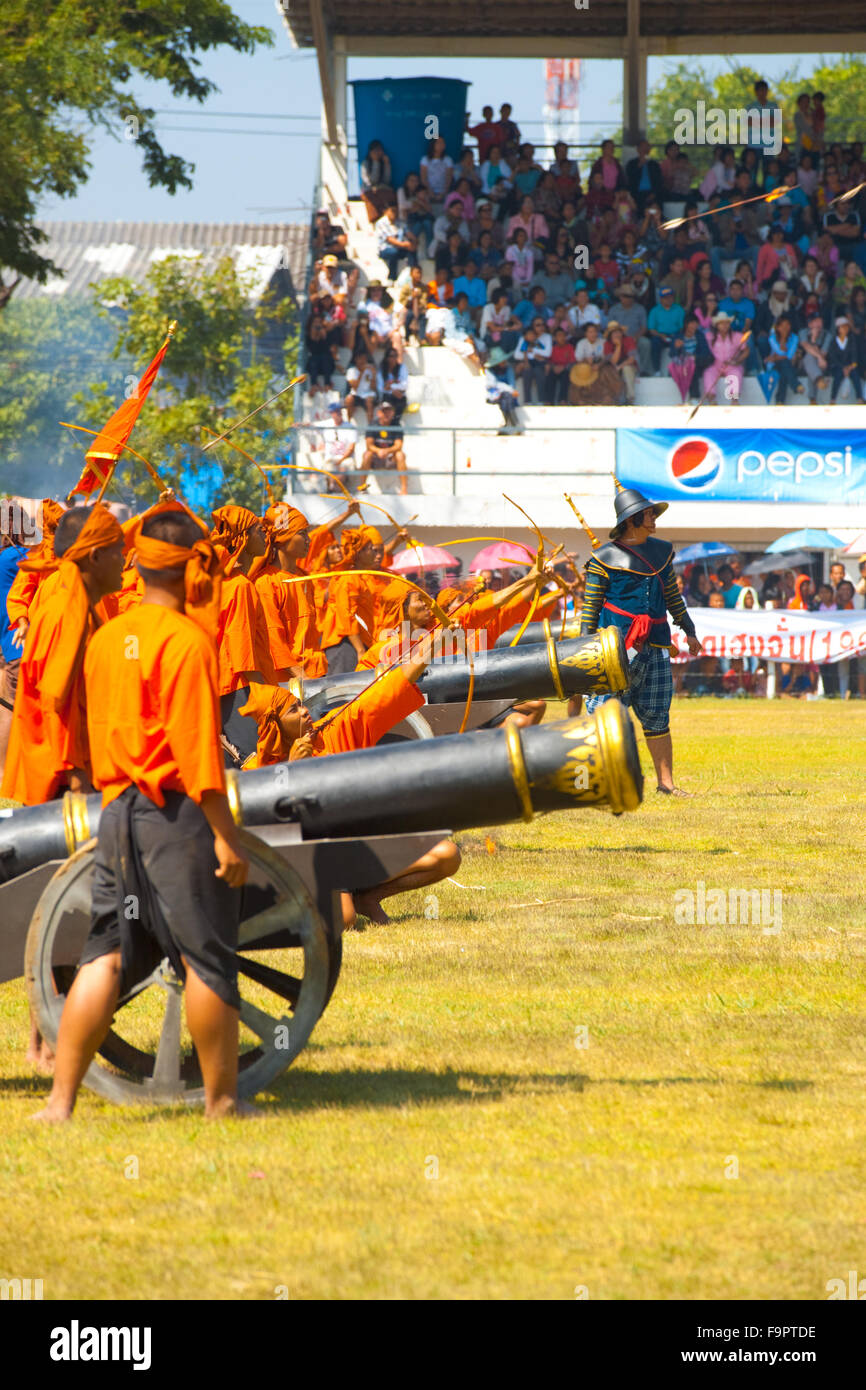 Archers de tir des canons et de l'uniforme orange de suite pendant un siamois birman de reconstitution de la guerre en face de la grande tribune Banque D'Images