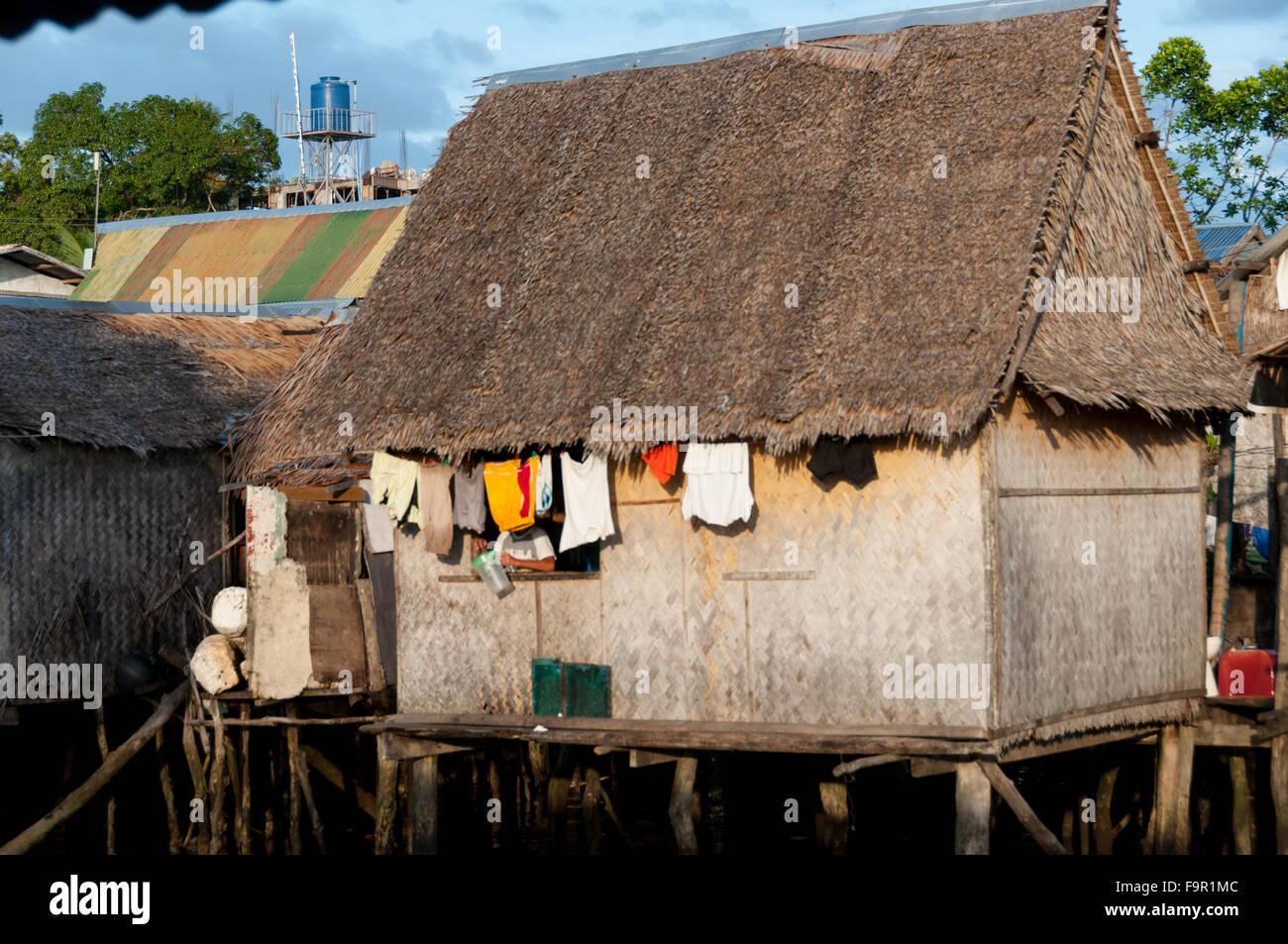 Petite maison en bois avec Nipa fermer la fenêtre sortir sur pilotis et de l'eau Banque D'Images