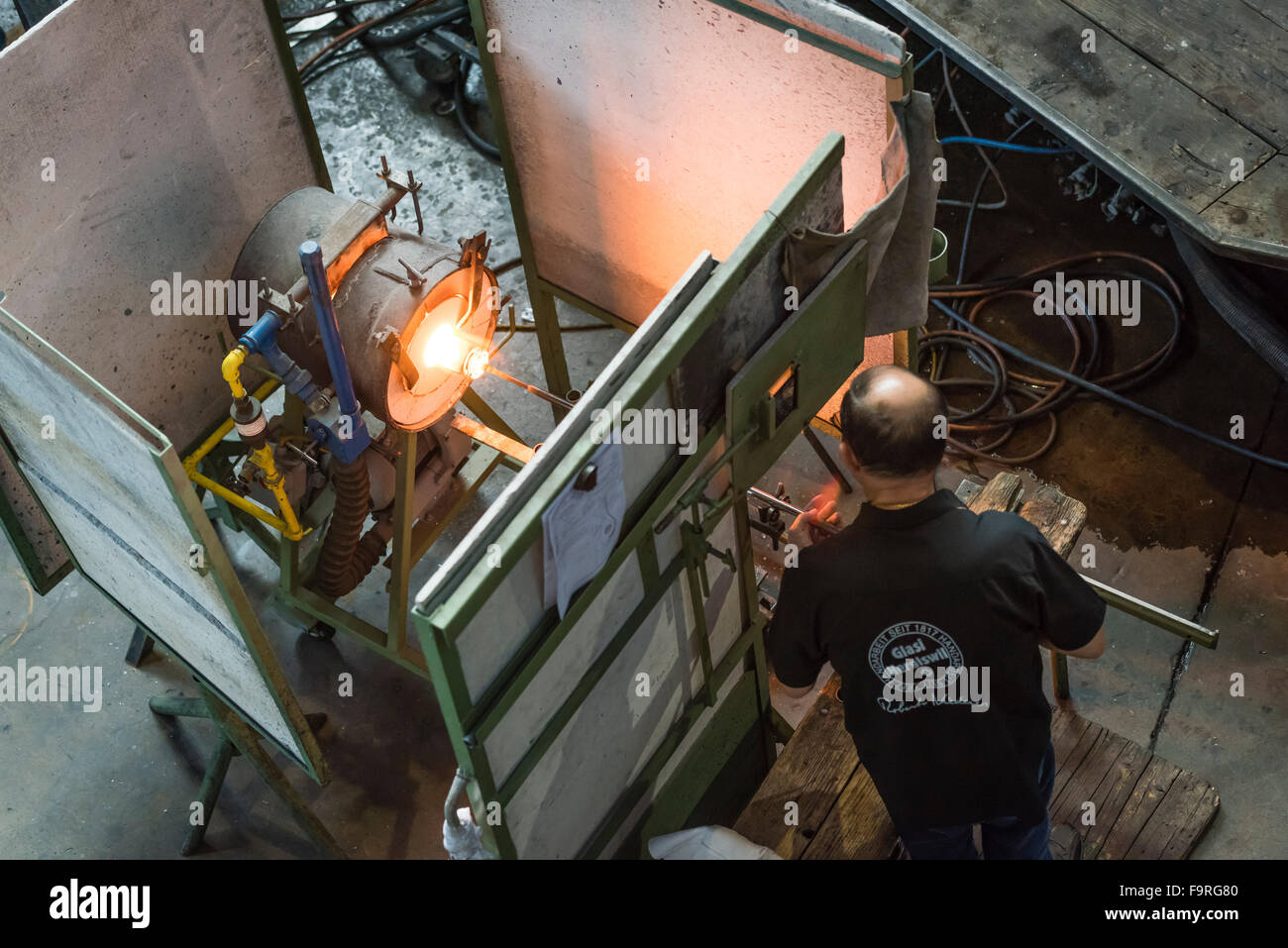 Un verrier au travail en face de la fournaise de la fabrication de verre soufflé traditionnel à Engelberg, Suisse. Banque D'Images
