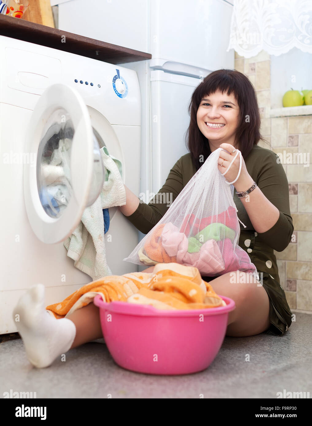 Happy housewife avec près de sac à linge lave-linge Banque D'Images