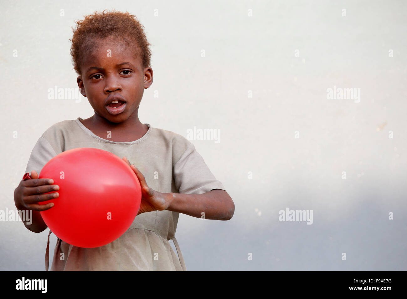 Jeune fille africaine jouant avec un ballon rouge. Banque D'Images