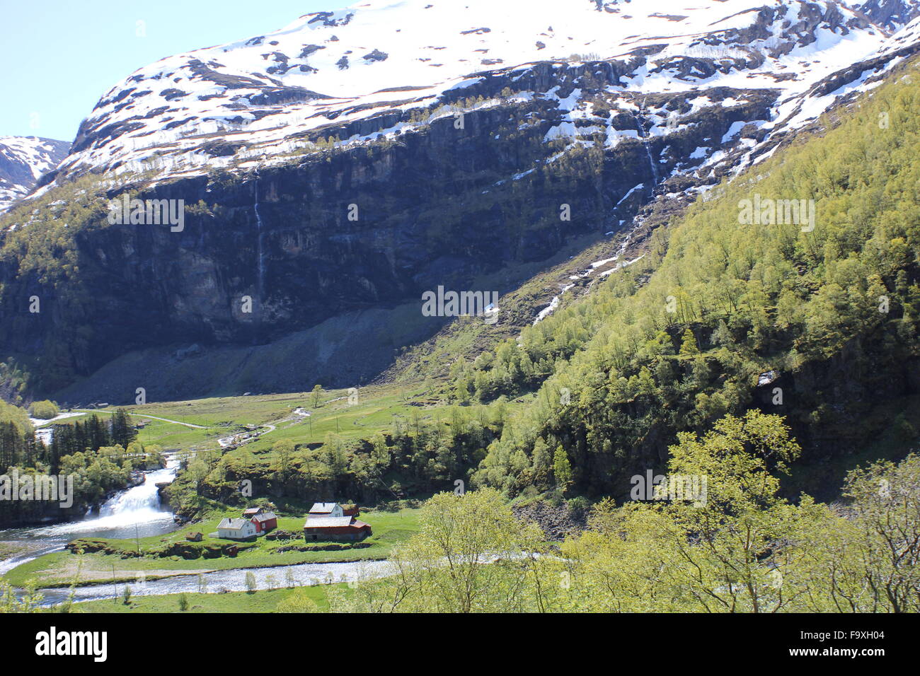 Vue depuis le Flamsbana in Norway (Flam Railway) d'un petit village avec une rivière et montagne Banque D'Images