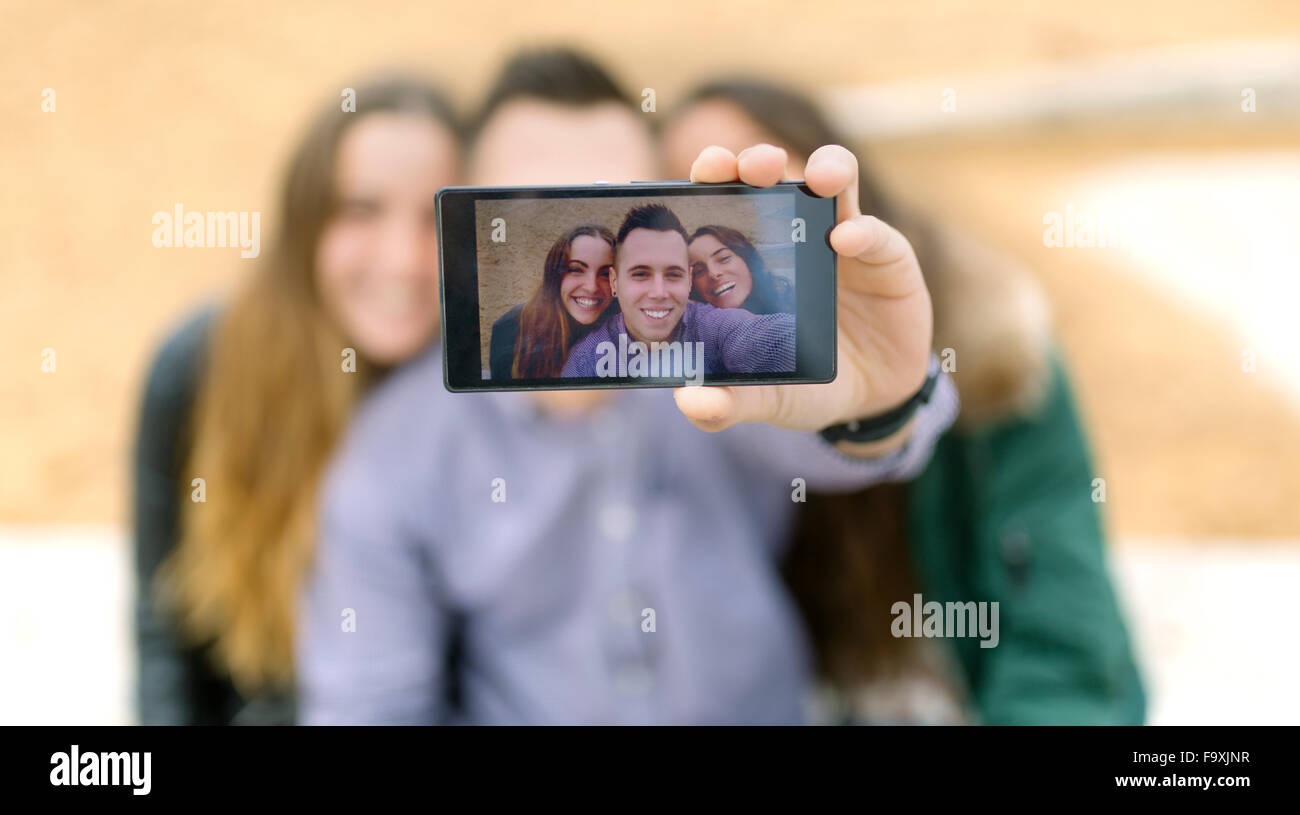 Des selfies smiling friends sur l'écran de smartphone Banque D'Images