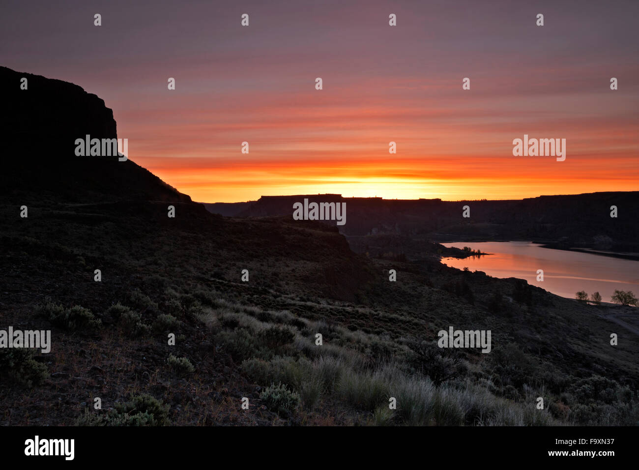 Aube sur Steamboat Rock et Devils Punch Bowl de bras de lac Banques Steamboat Rock State Park dans le Upper Grand Coulee. Banque D'Images