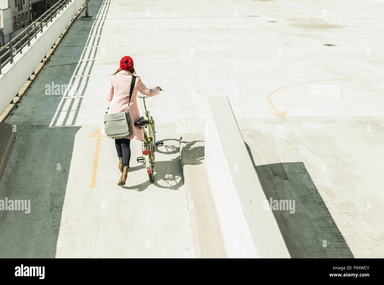 Jeune femme poussant sur le niveau parking vélos Banque D'Images