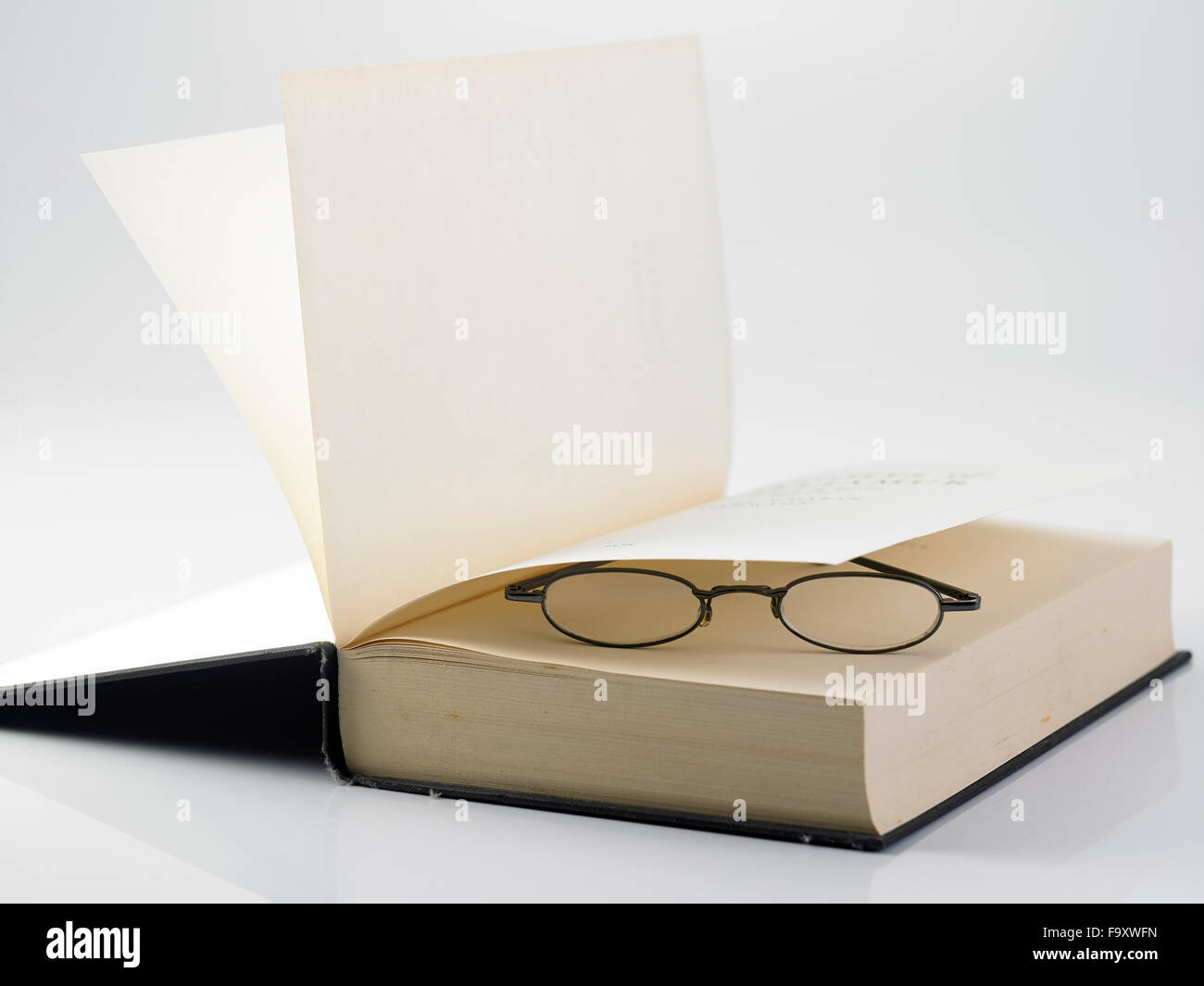 Ouvrir un livre relié avec une paire de lunettes de lecture Banque D'Images