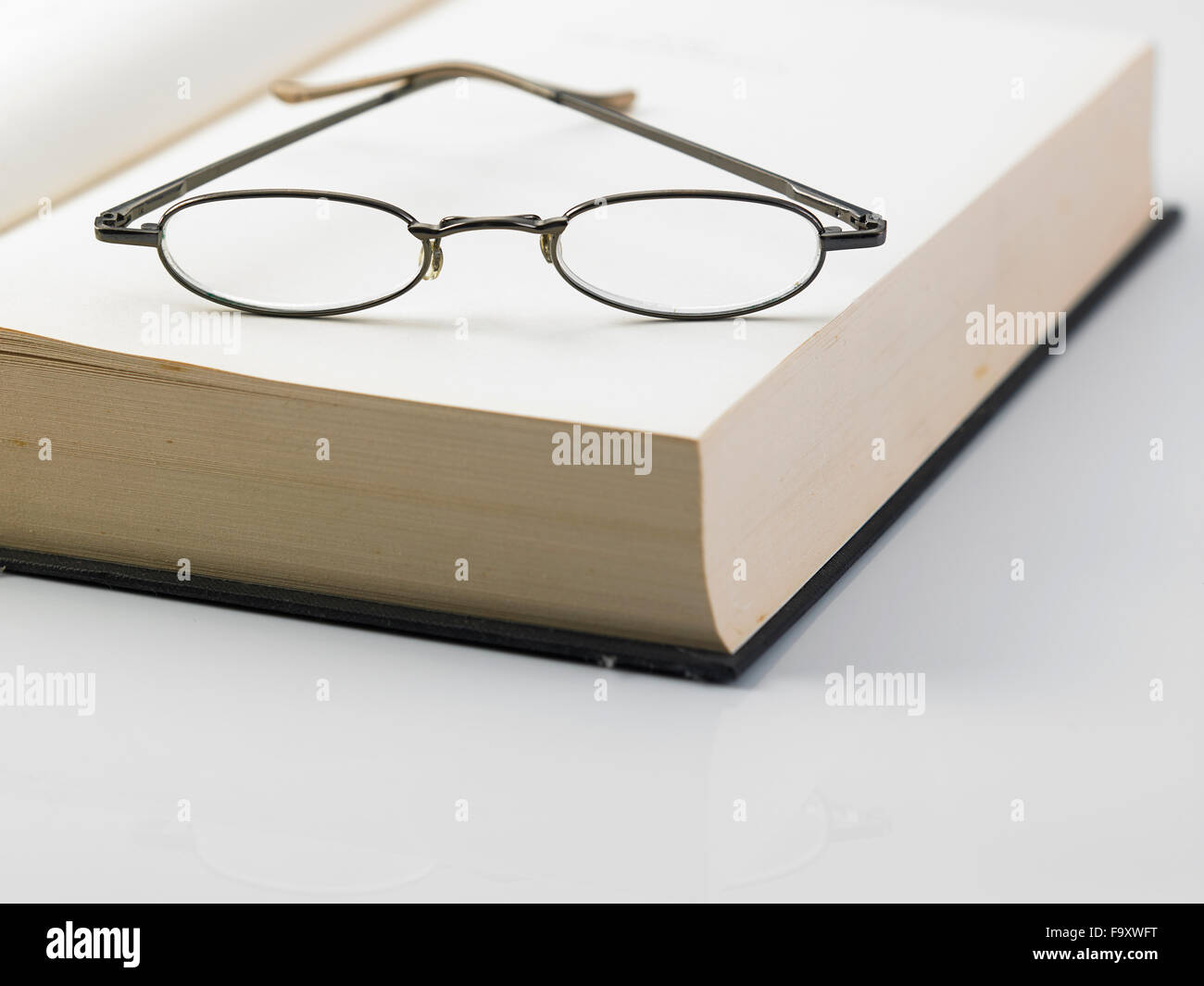 Ouvrir un livre relié avec une paire de lunettes de lecture Banque D'Images