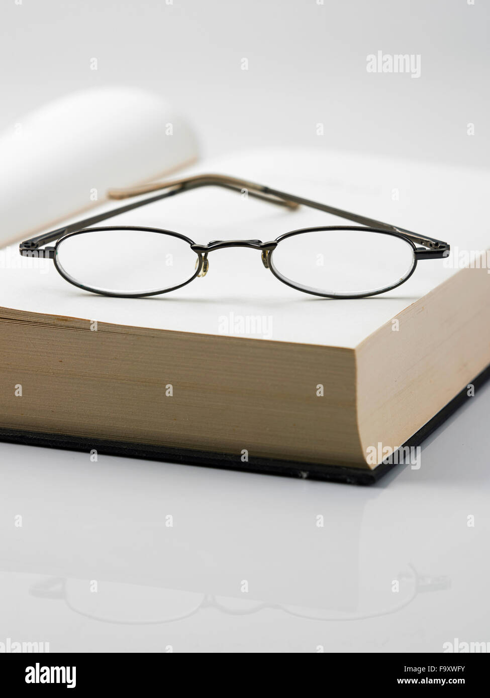 Ouvrir un livre relié avec une paire de lunettes de lecture Banque D'Images