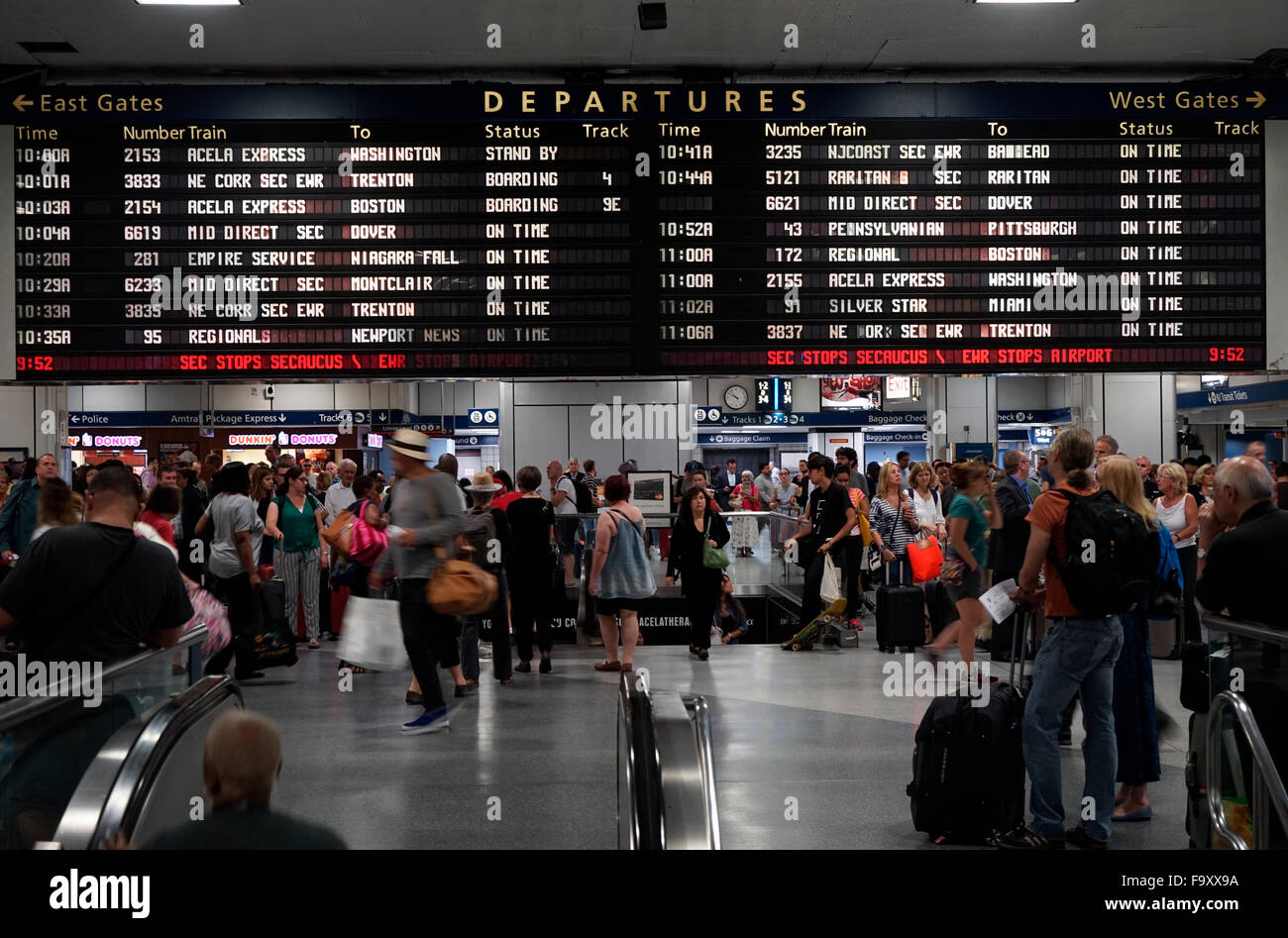 Les gens à l'intérieur de la gare Penn Station avec écran d'information de départ en arrière-plan.Manhattan, New York City, USA Banque D'Images