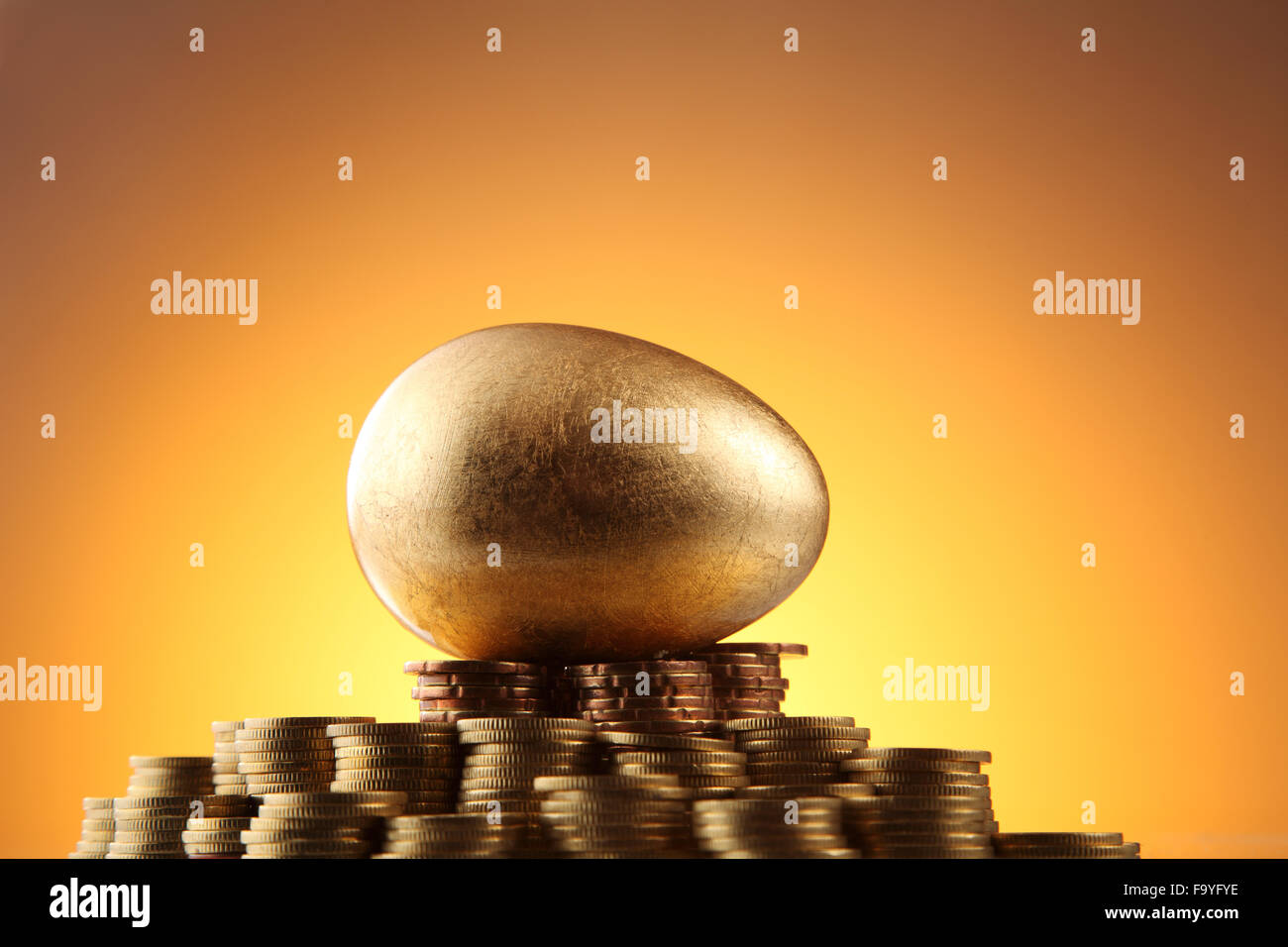 Œuf d'or reste sur des piles de pièces de monnaie Banque D'Images