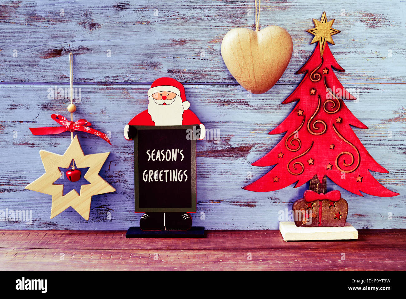Une ardoise en forme de Père Noël avec le texte meilleurs vœux contre un fond rustique en bois bleu avec quelques différents Banque D'Images
