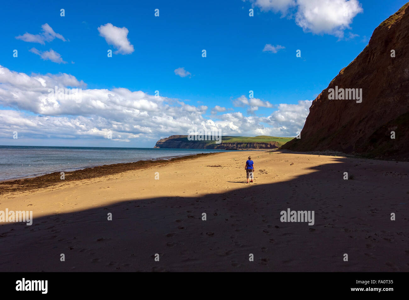 Figure solitaire sur Skinningrove beach, golden sands et ciel bleu, North Yorkshire Banque D'Images