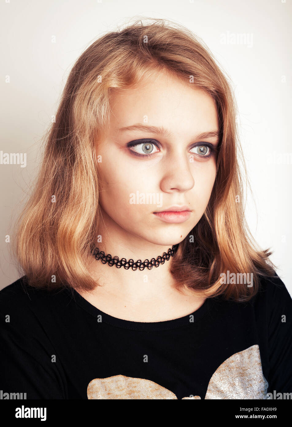 Fille Blonde Adolescente Avec Pinceau De Maquillage Sur Mur Isolé