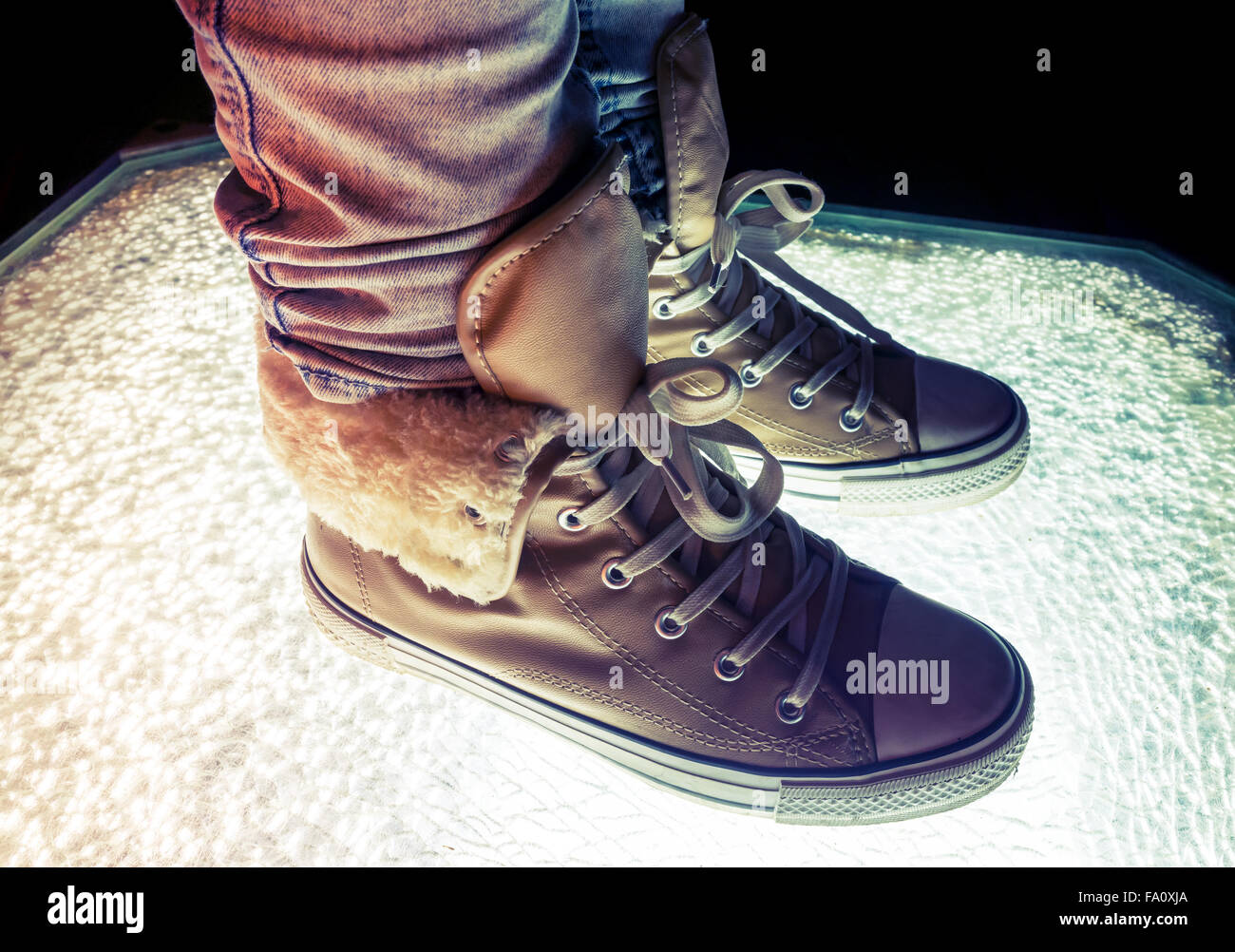 Chaussures de sport, chaussures chaudes debout sur verre fissuré, correction tonale colorés, filtre photo style rétro Banque D'Images