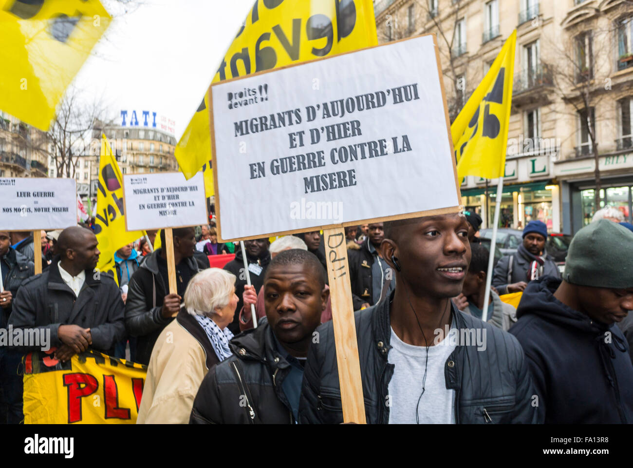 Paris, France, droits des immigrants migrants, sans papiers, démonstration,Foule avec un Africain tenant une affiche de protestation militante française dans la rue « les manrants d'aujourd'hui et d'hier, à la guerre contre la misère » (droits dévant », ONG), manifestations sociales, immigrants internationaux, travailleurs immigrés, protestation pour la justice,signe de protestation pacifique Banque D'Images