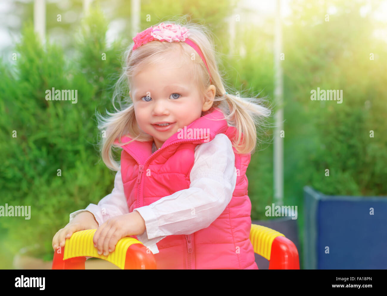 Portrait de petite fille blonde s'amuser sur l'aire de jeux dans chaude journée ensoleillée, adorable Enfant jouant à l'extérieur Banque D'Images