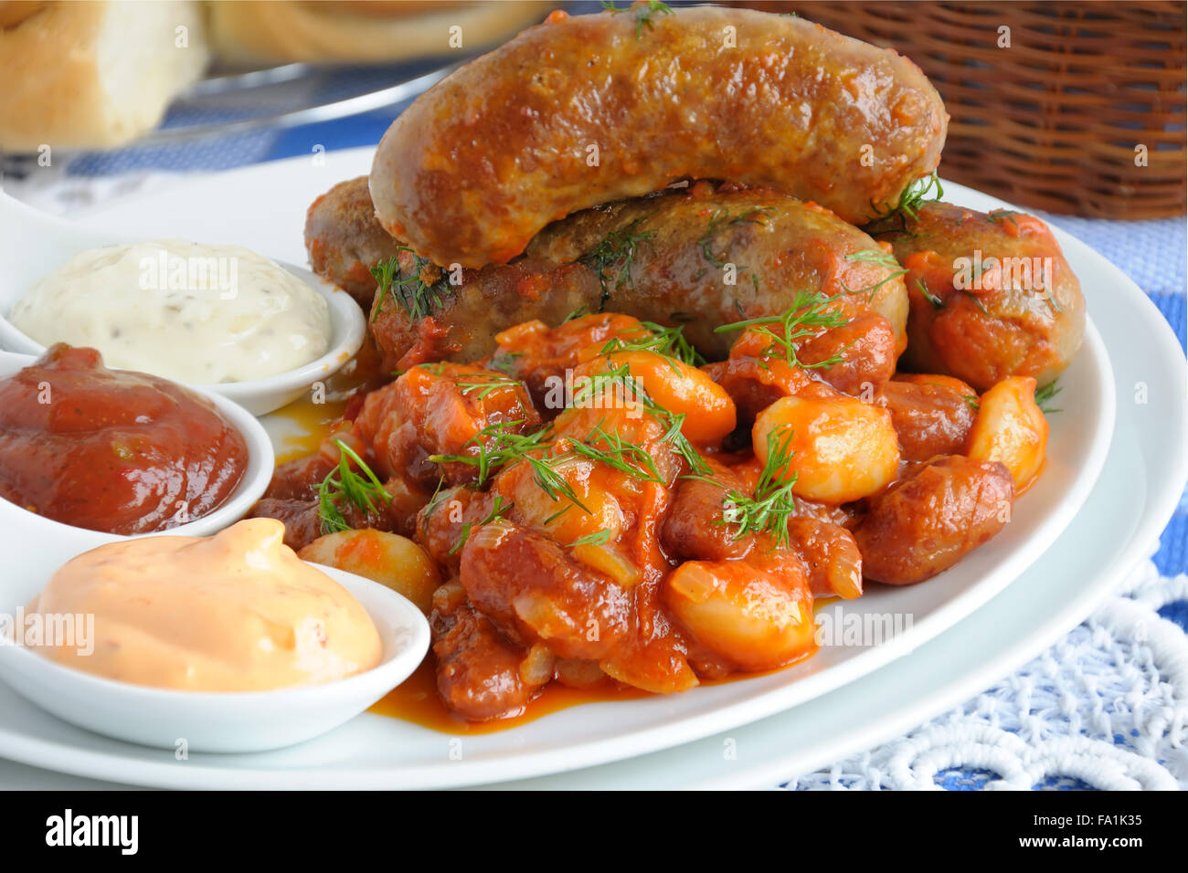 Accueil saucisse avec les haricots, les oignons et les carottes dans une sauce tomate Banque D'Images