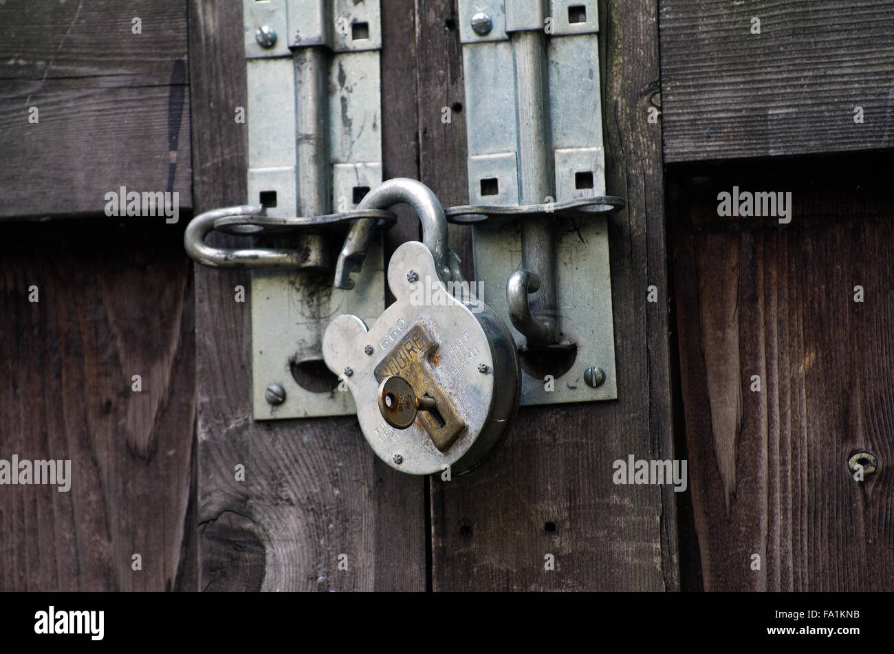 Ouvrir un cadenas sur une porte en bois Banque D'Images