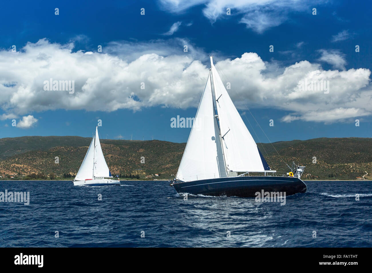 Bateau à voile yachts avec voiles blanches dans une rangée sur la mer. Banque D'Images