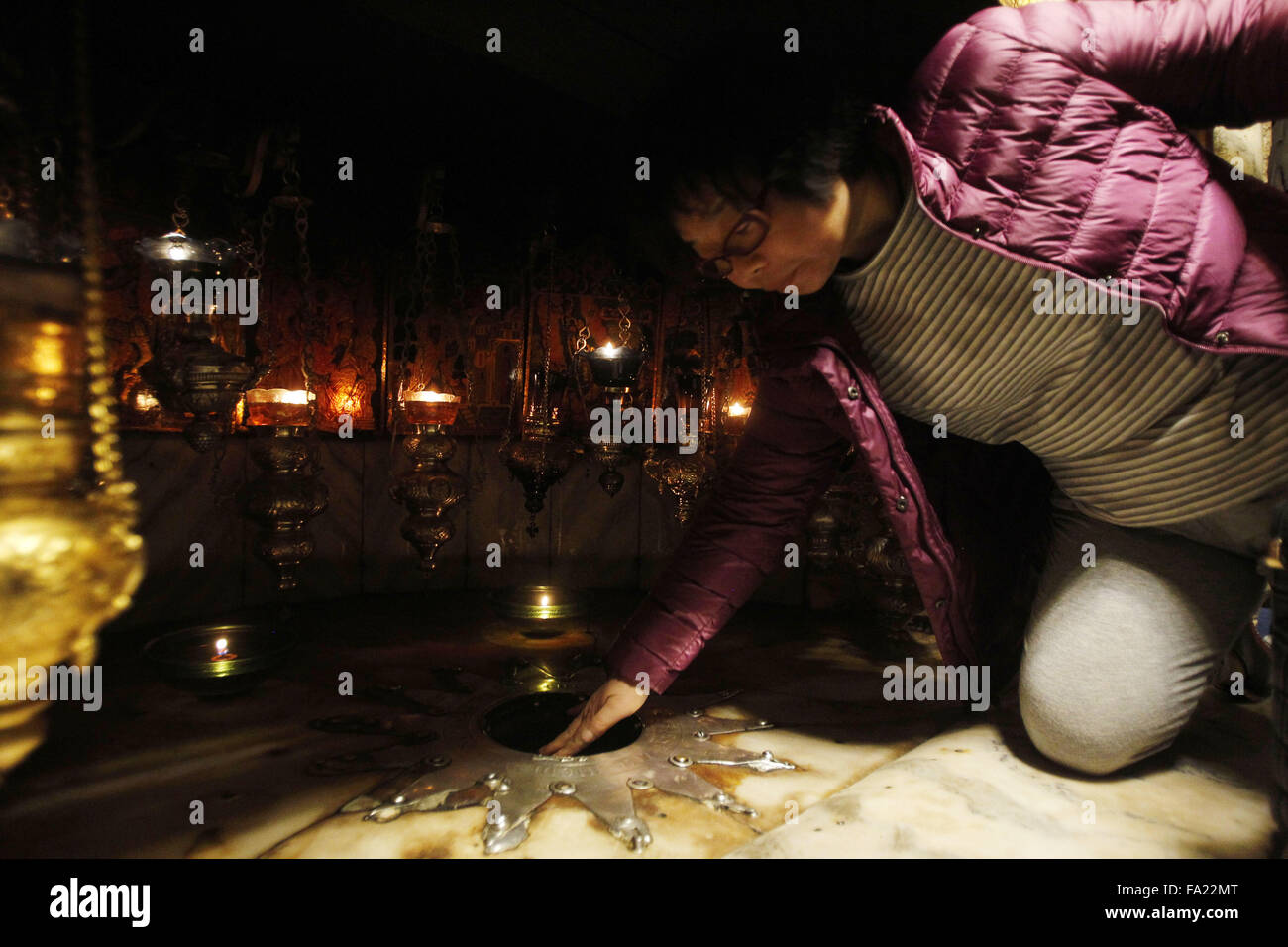Bethléem, Cisjordanie, territoire palestinien. 18Th Oct, 2015. Un chrétien fidèle touche un 14 pointes silver star à la Grotte de l'église de la Nativité, croyait que la naissance de Jésus Christ, dans la ville cisjordanienne de Bethléem, le 20 décembre 2015 © Hashlamoun Wisam/APA/Images/fil ZUMA Alamy Live News Banque D'Images