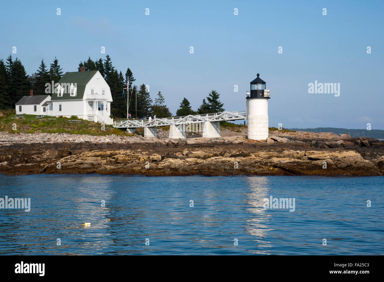 Vue sur l'eau sortie du Port Port Clyde passant par Marshall Point Lighthouse dans le Maine sur un début de soirée d'été. Banque D'Images