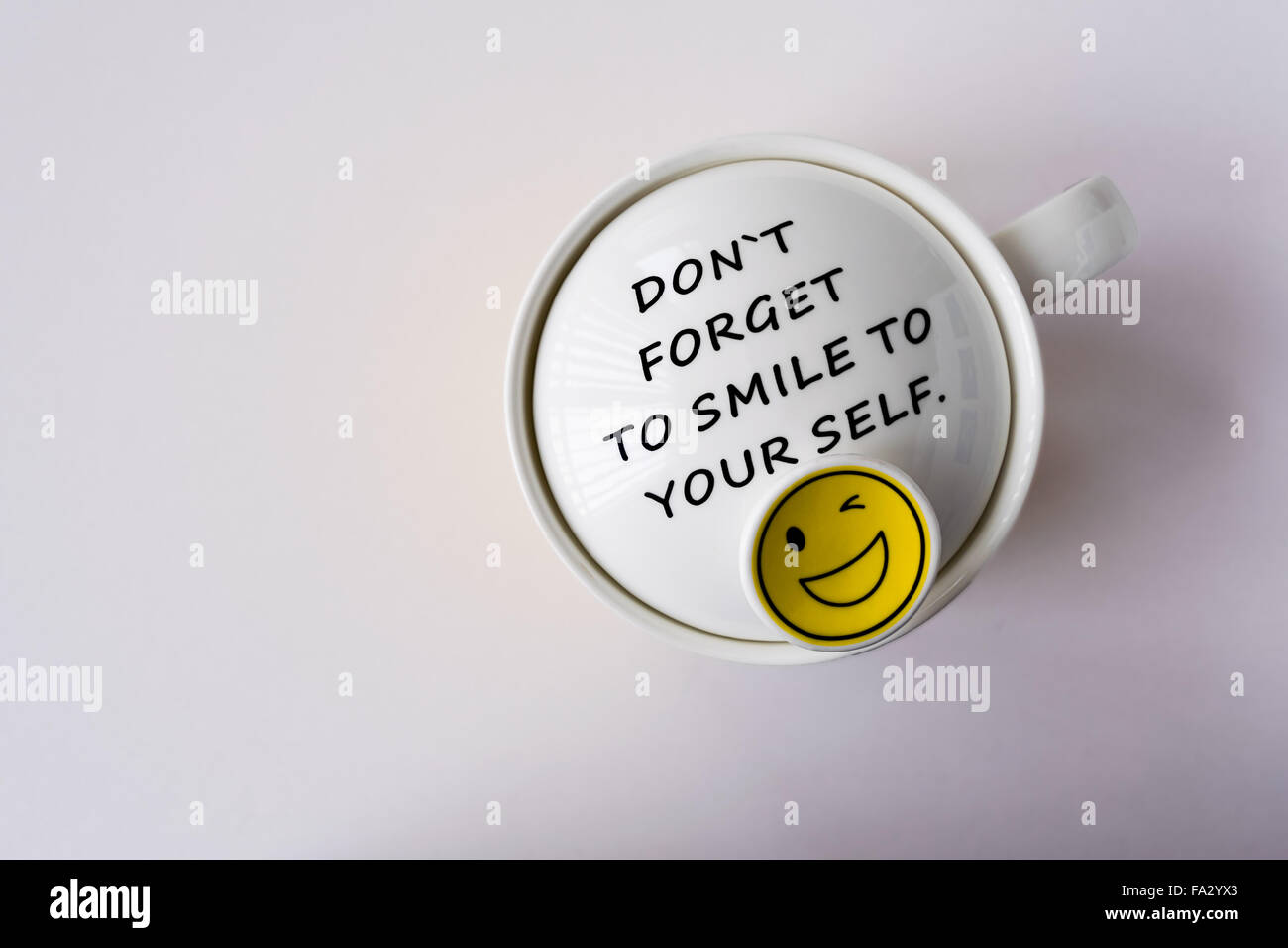 Un mug blanc avec une citation positive disant n'oubliez pas de sourire à votre auto Banque D'Images
