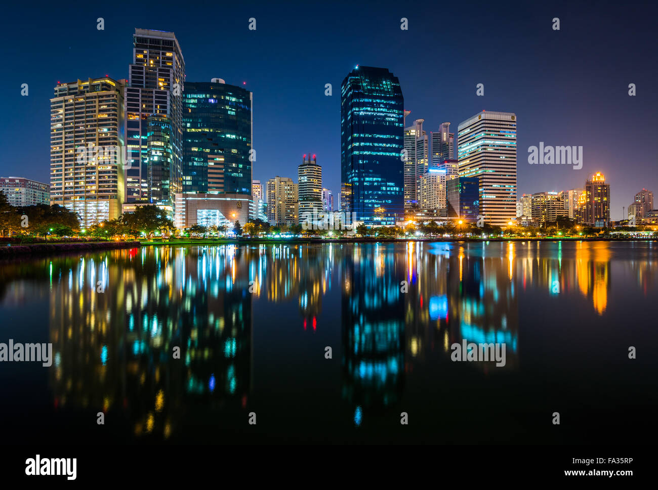 Les gratte-ciel modernes et le lac Rajada la nuit, au parc Benjakiti, à Bangkok, Thaïlande. Banque D'Images