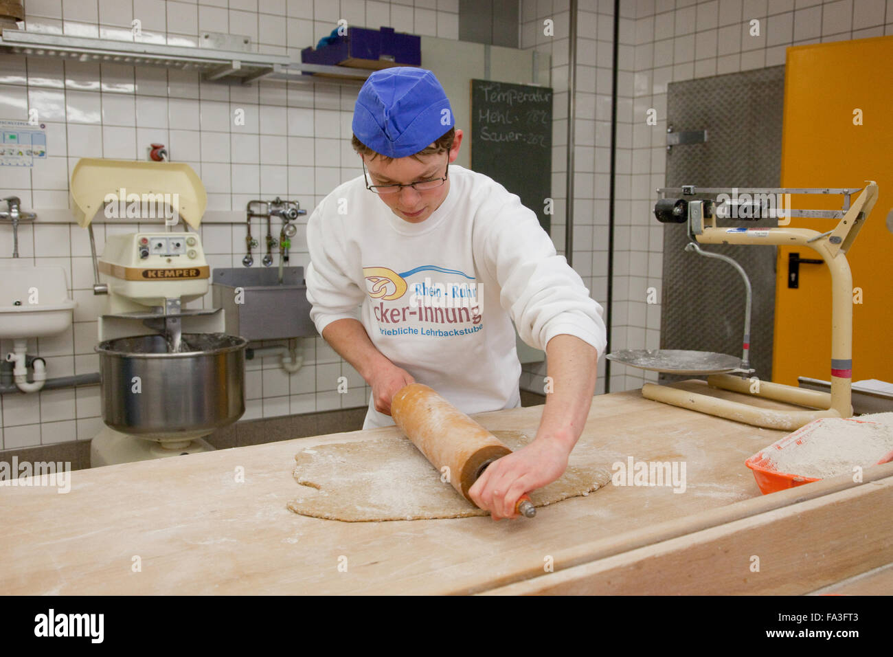 Apprenti boulanger pétrit la pâte à pain. Banque D'Images