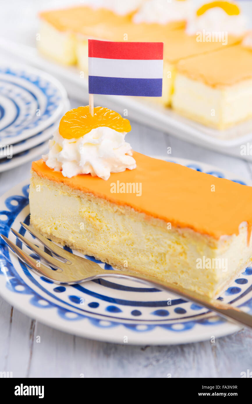 Un tompouce orange, pâtisserie traditionnelle hollandaise, sur un fond blanc. L'orange cerise sur le tompouce est typique pour la fête du Roi Banque D'Images