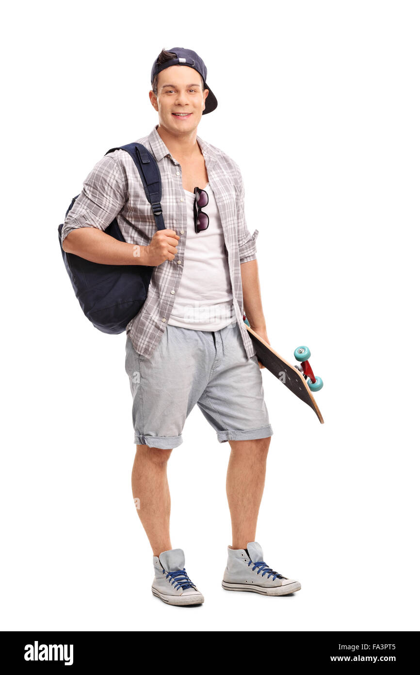Portrait d'un jeune skater tenant un skateboard et portant un sac à dos bleu isolé sur fond blanc Banque D'Images