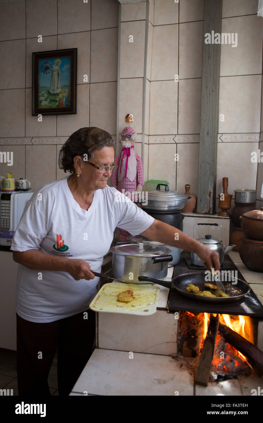 Amérique du Sud, Brésil, Sao Paulo. Une femme locale cuisine dans sa cuisine sur un forno traditionnel au bois un poêle à lenha Banque D'Images