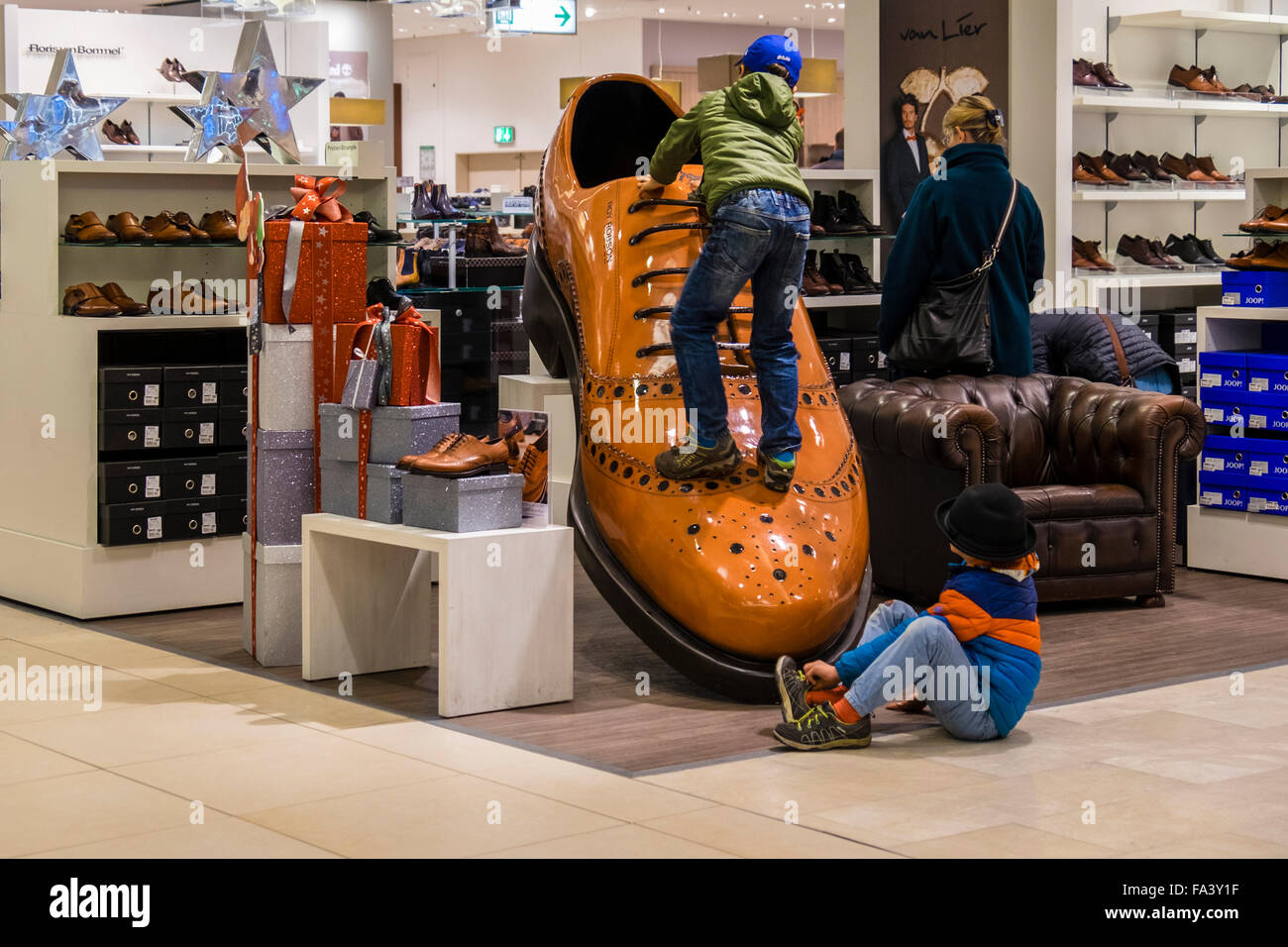 Deux jeunes garçons jouent sur chaussure géante de l'écran en grand magasin  Galeria Kaufhof Berlin, Allemagne Photo Stock - Alamy