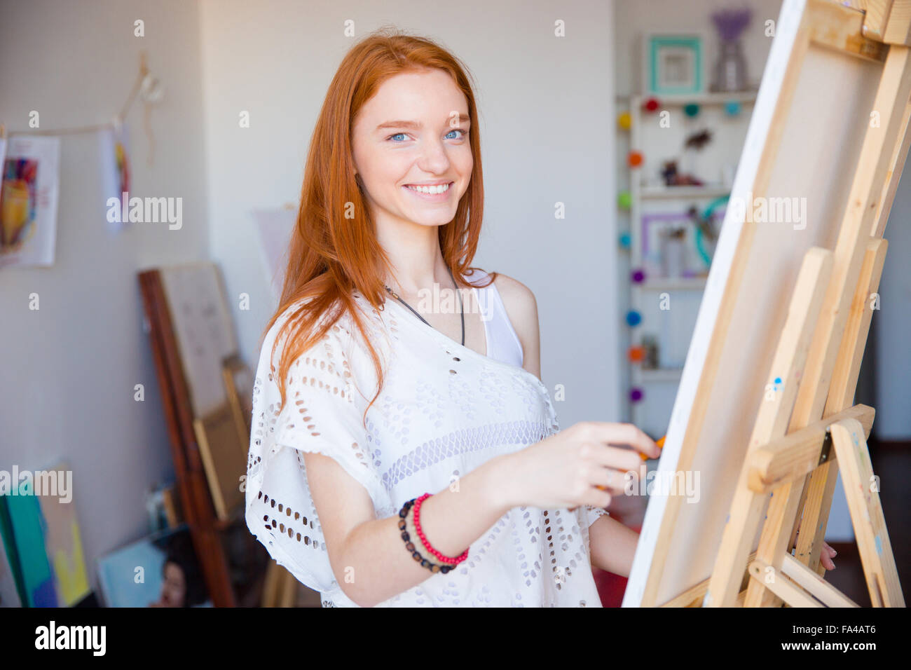 Joli mignon jeune rouquine joyeuse femme artiste profitant de dessin dans un atelier d'art Banque D'Images