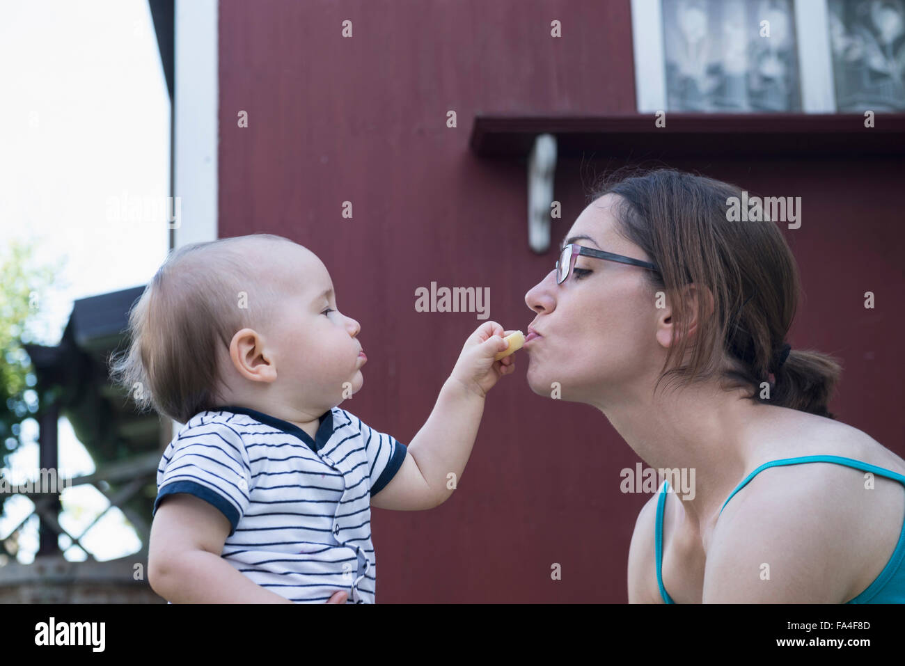 Alimentation Bébé garçon sa mère en pelouse, Munich, Bavière, Allemagne Banque D'Images