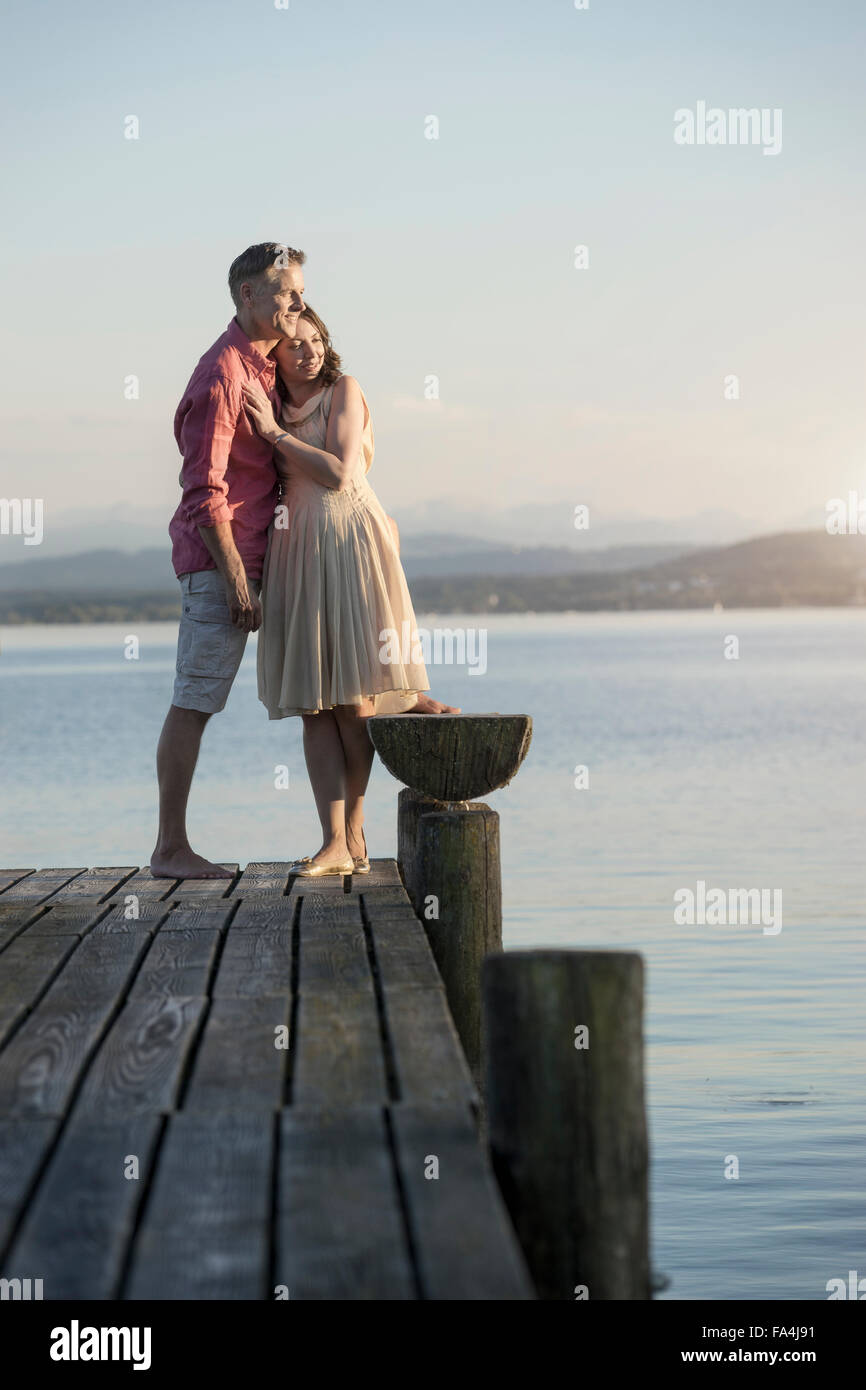 Mature couple standing on pier et surplombant le lac, Bavière, Allemagne Banque D'Images