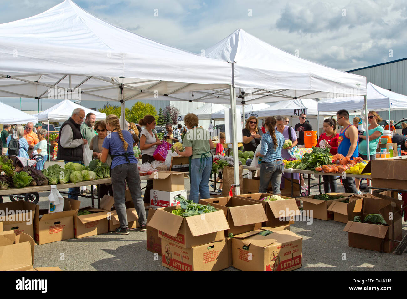 Marché de producteurs du sud d'Anchorage, Shoppers, forfaits de communication avec les clients. Banque D'Images