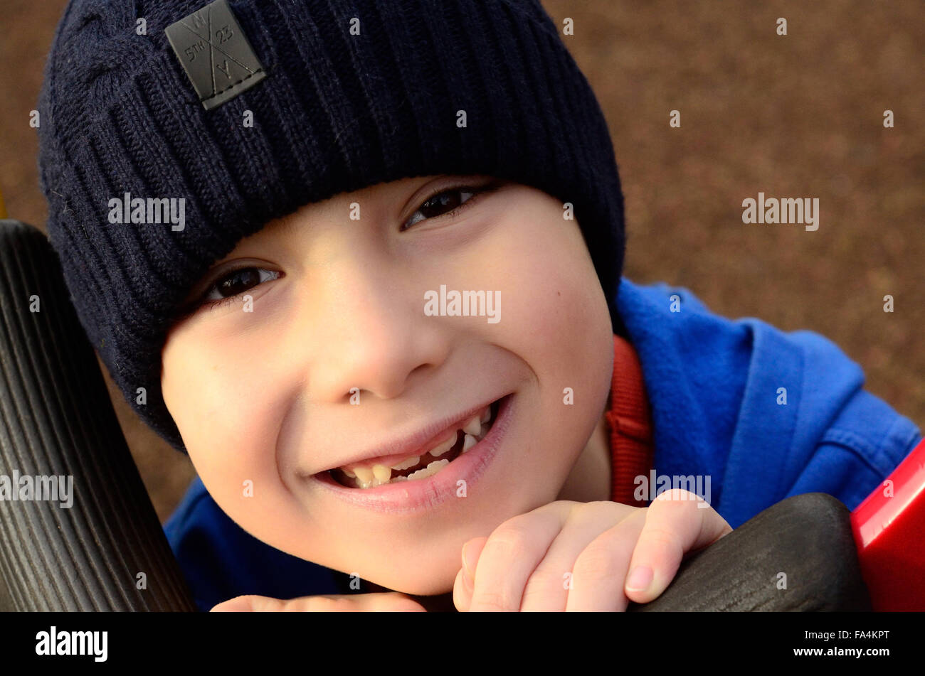 Un jeune garçon avec un sourire Gappy Ranks portant un Beanie Hat. Banque D'Images