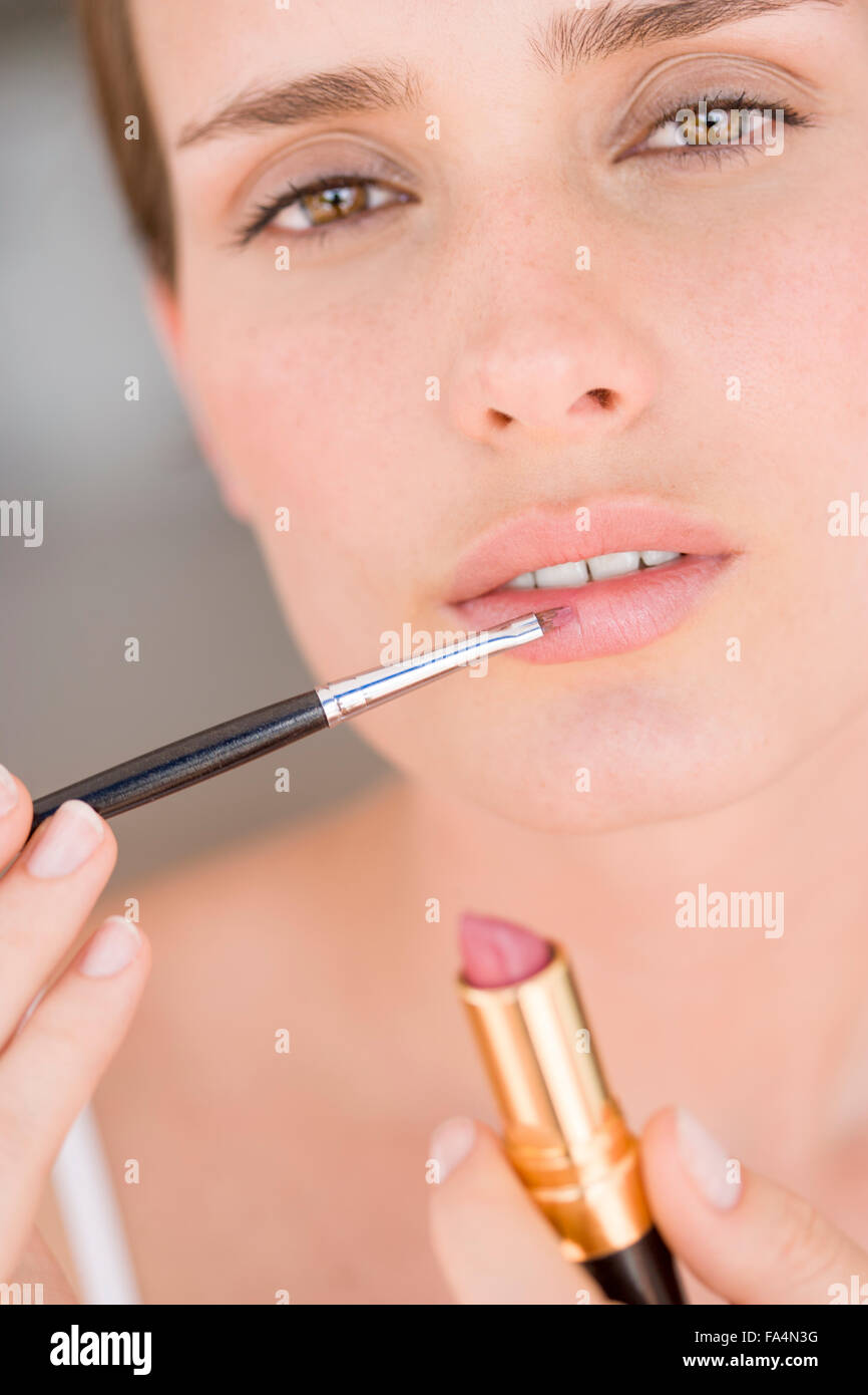 Portrait of young woman applying makeup Banque D'Images