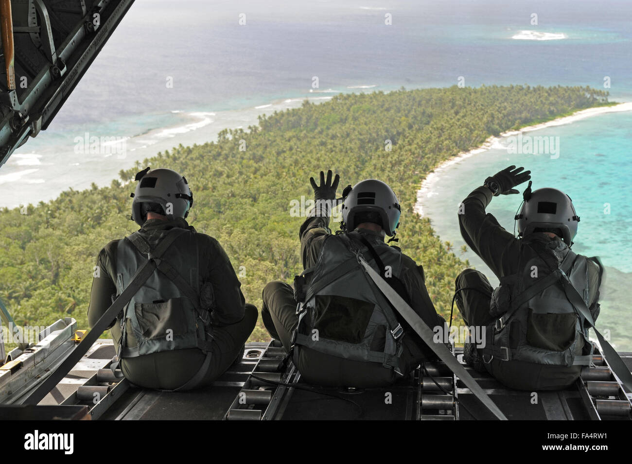 Les aviateurs de l'US Air Force vague à l'arrière de leur C-130 Hercules après la chute de l'air au cours de l'Opération Goutte de Noël cadeaux 11 Décembre, 2015 en Micronésie. Noël opération Drop est la plus longue opération humanitaire du ministère de la Défense portant sur 56 îles du Pacifique à distance. Banque D'Images