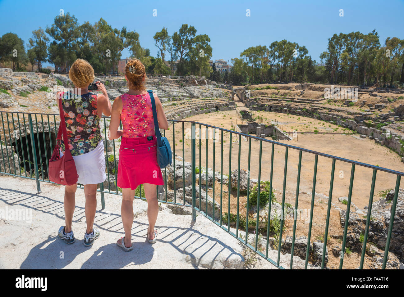 Les femmes voyagent, vue arrière de deux amis en visite dans les ruines de l'amphithéâtre romain dans le parc archéologique de Syracuse, Sicile, Banque D'Images