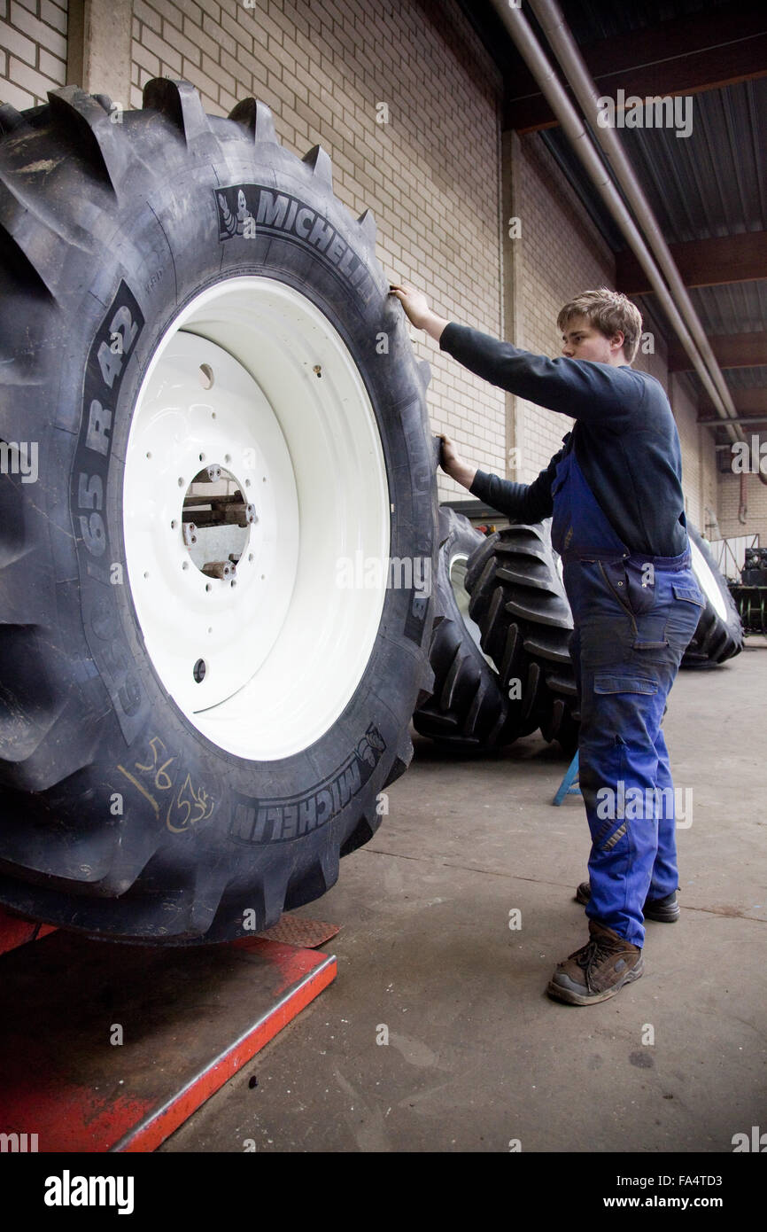 Apprenti ajusteur changer un pneu du tracteur. Banque D'Images