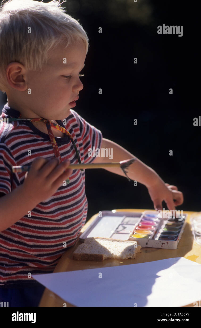 Jeune garçon peindre avec les peintures de l'affiche. Banque D'Images