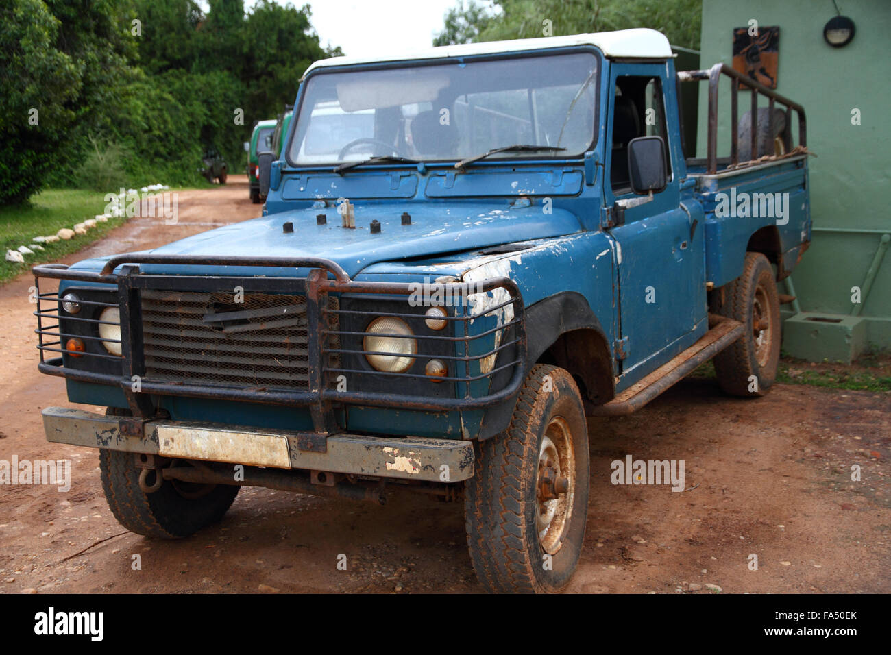 Un battement de vieux camion safari bleu couvert de saleté, de rouille, et avec des fragments de peinture Banque D'Images