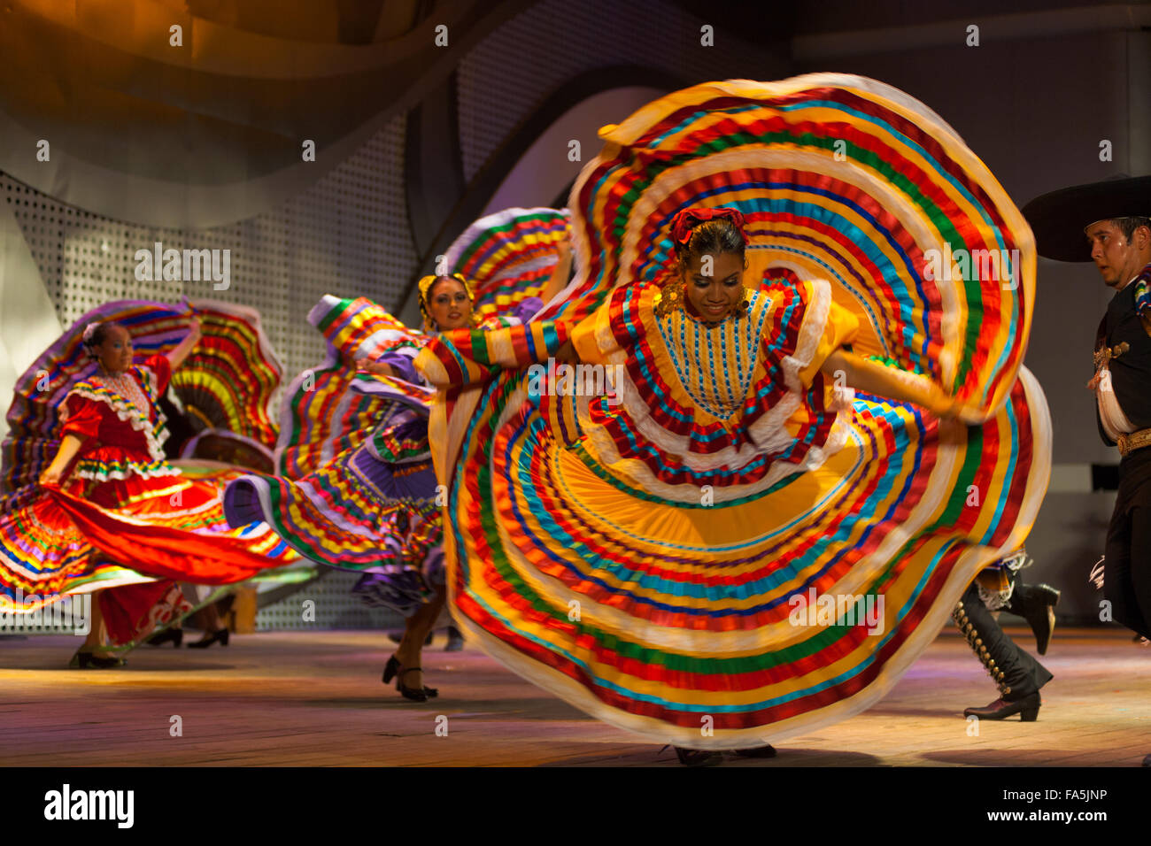Belle femme danseur mexicain, de spinning et de répandre sa robe jaune coloré lors d'un spectacle folklorique traditionnel à un pu Banque D'Images