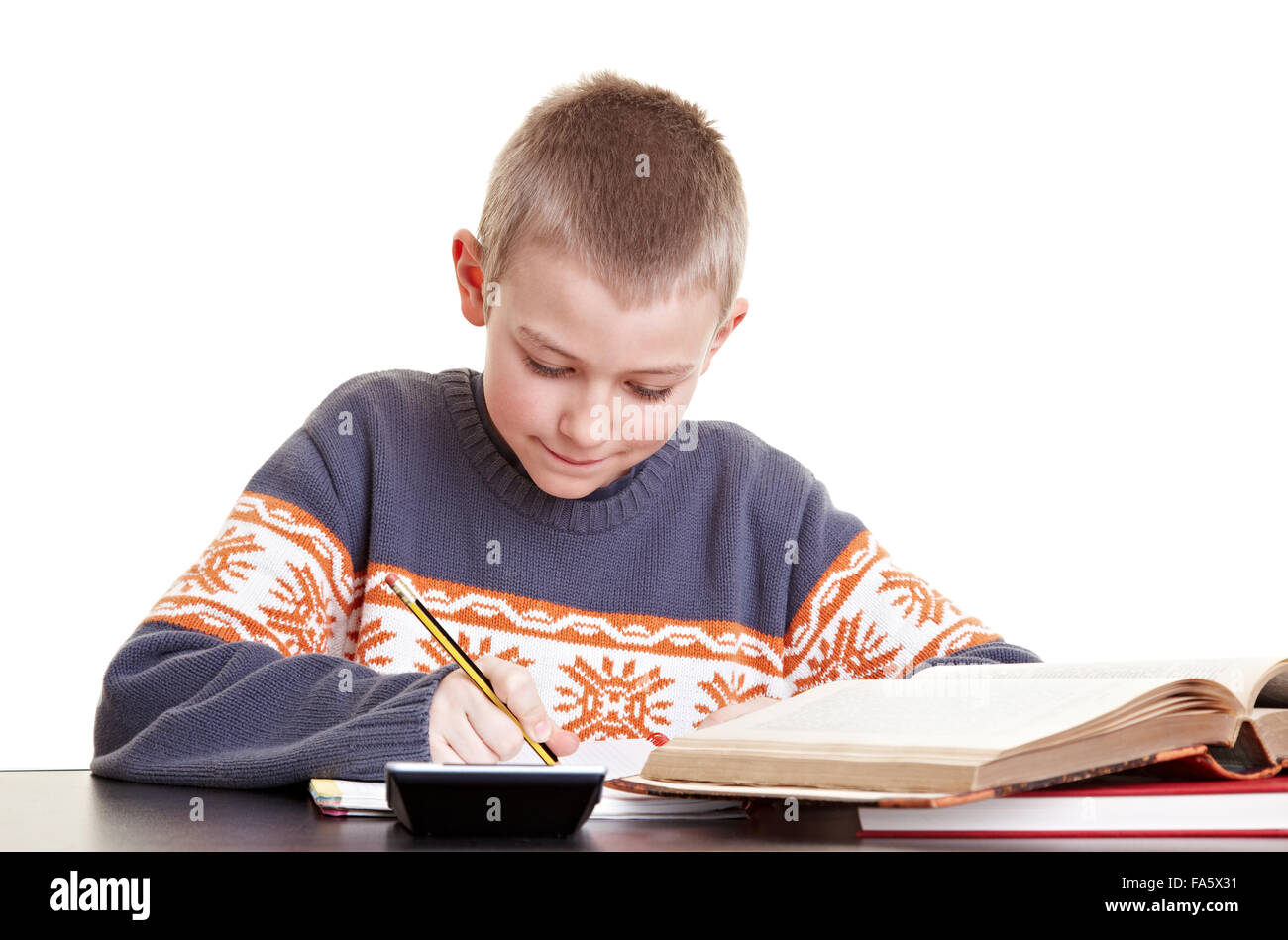 Garçon diligent à travailler sur ses devoirs à son bureau. Banque D'Images