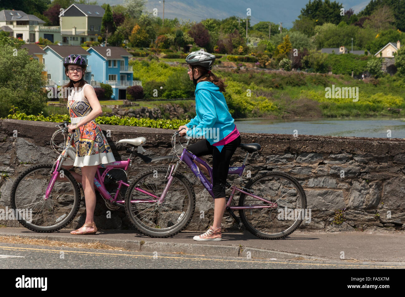 Cyclisme en Irlande.et deux jeunes touristes féminins au pont de Killorglin au-dessus de la rivière Laune, comté de Kerry, Irlande. Banque D'Images