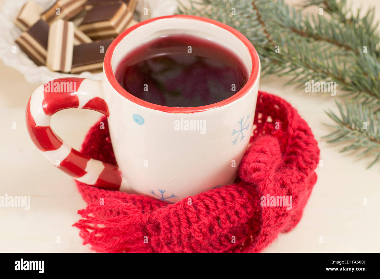 Tasse de thé de Noël couverts par l'écharpe d'hiver avec sapin en arrière-plan Banque D'Images