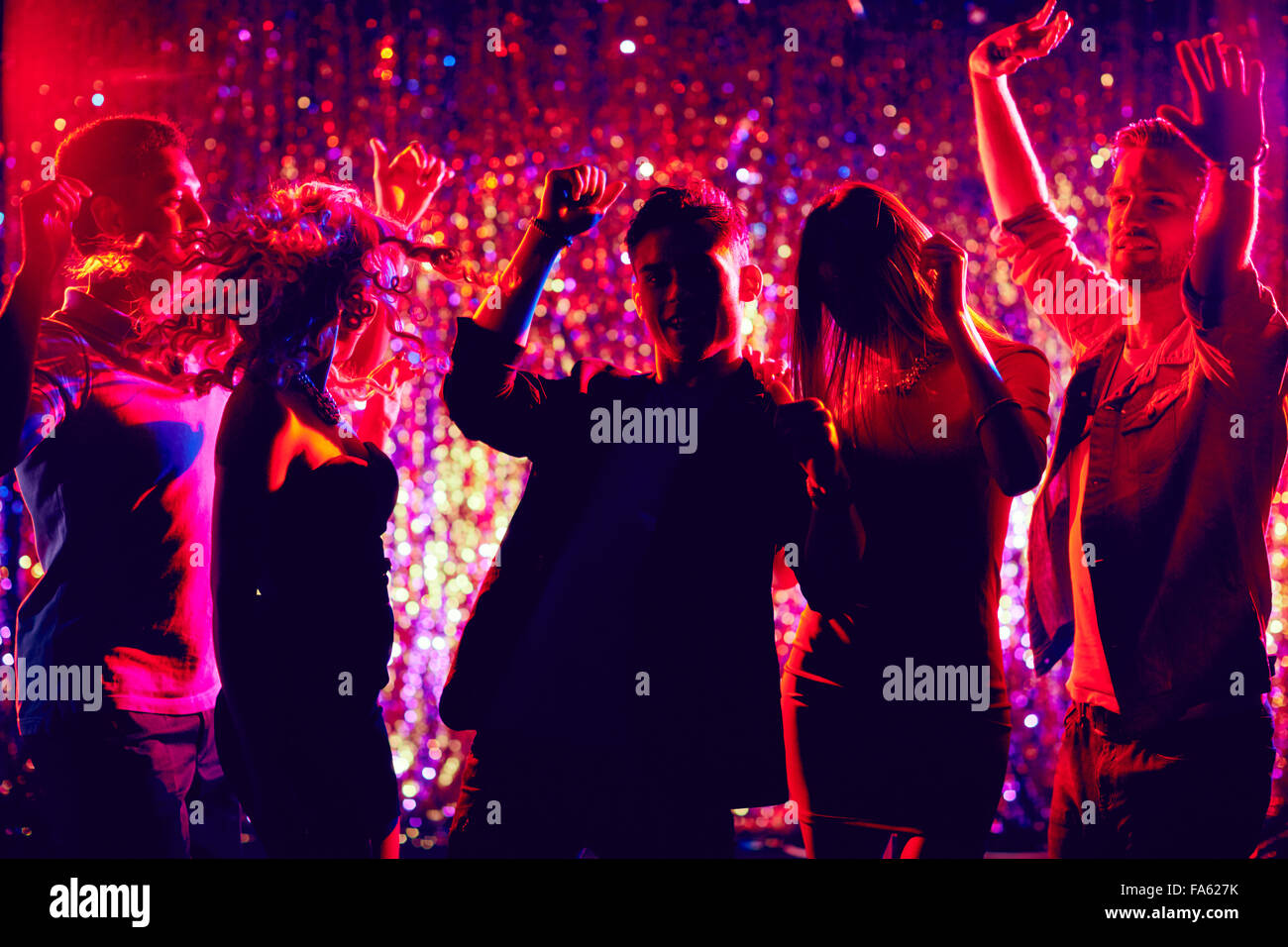 Happy young people dancing at party at night Banque D'Images