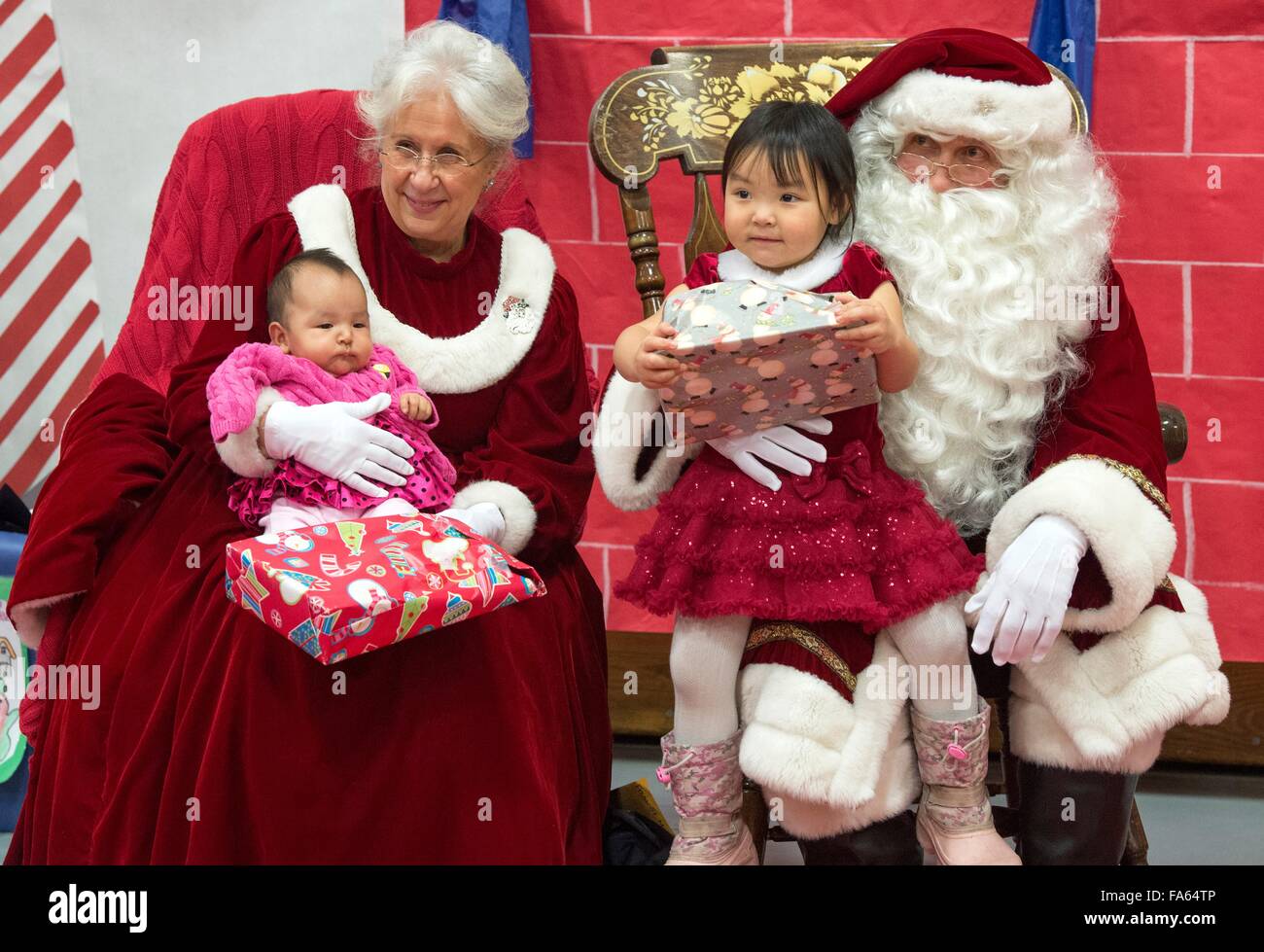 Le Père Noël et Mme Noël Alaska Native accueillent les enfants lors d'une visite dans les villages éloignés dans le cadre de l'Opération Père Noël 5 décembre 2015 à Saint Mary's, de l'Alaska. Le programme a été organisé pour 59 ans et apporte de Noël aux groupes mal desservis, les villages éloignés à travers l'Alaska. Banque D'Images